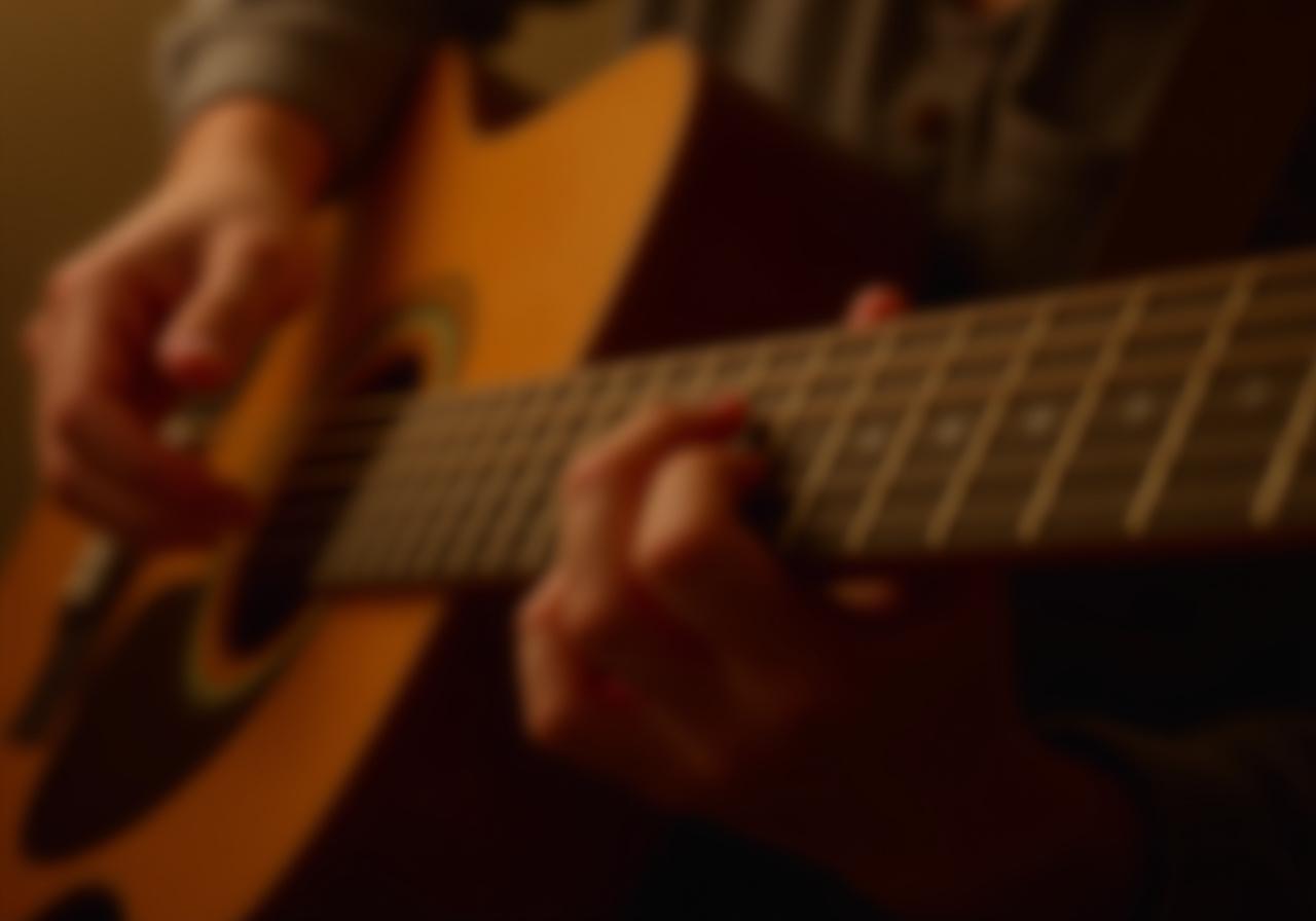 Close up of hands on a guitar fretboard