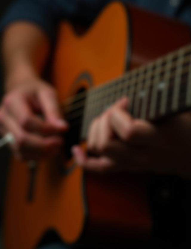 Student practicing guitar chord during a private coaching session
